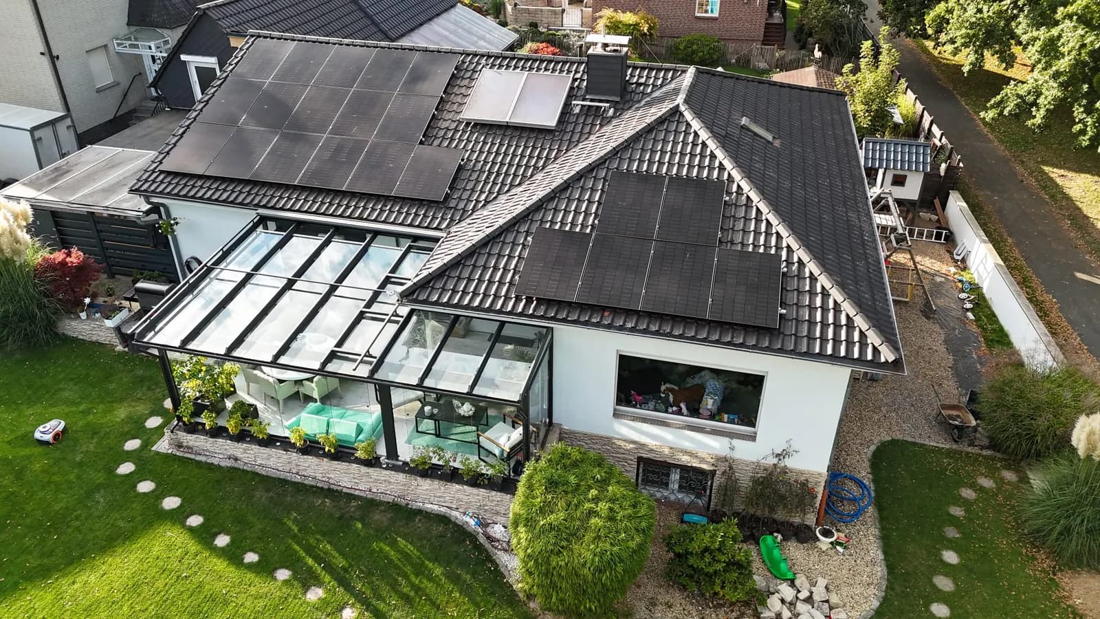 Wohnhaus mit Wintergarten und einer von Sunna installierten Photovoltaikanlage aus der Vogelperspektive